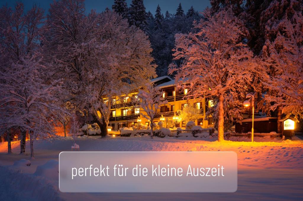 Hotel Ruchti - Zeit für mich في فوسن: مبنى مغطى بالثلوج في الليل مع الأشجار