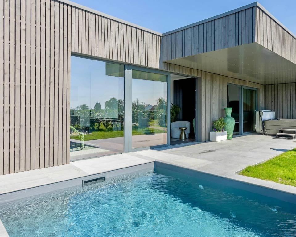 a swimming pool in front of a house at Nomad Village in Verviers