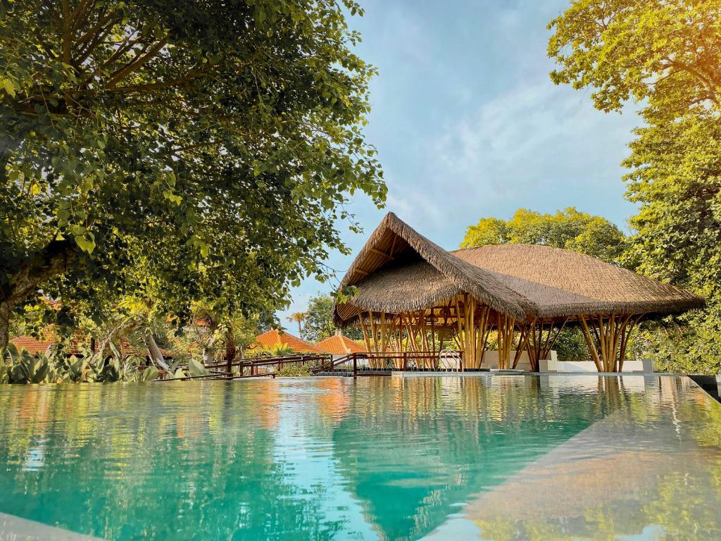 ein Resort mit Schwimmbad und Hütte in der Unterkunft eL Hotel & Resort Bali Sanur in Sanur