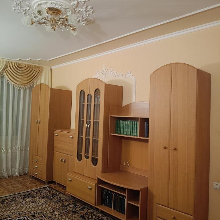 a room with wooden cabinets and a chandelier at Квартира in Sumy