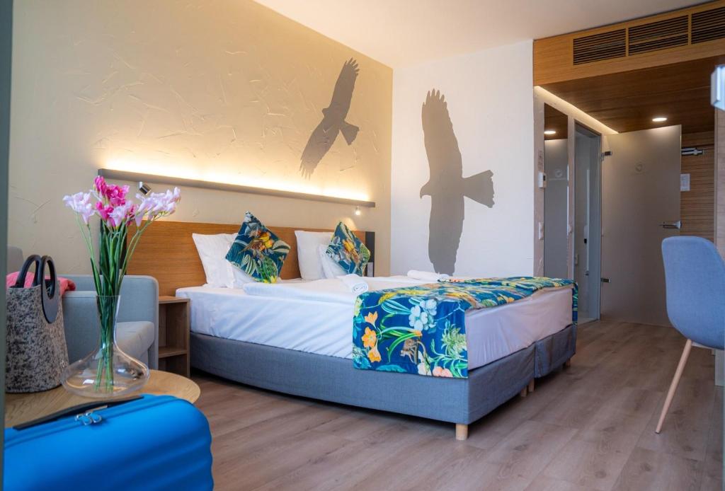 a hotel room with a bed and a table and chairs at Pangea Hotel in Nyíregyháza