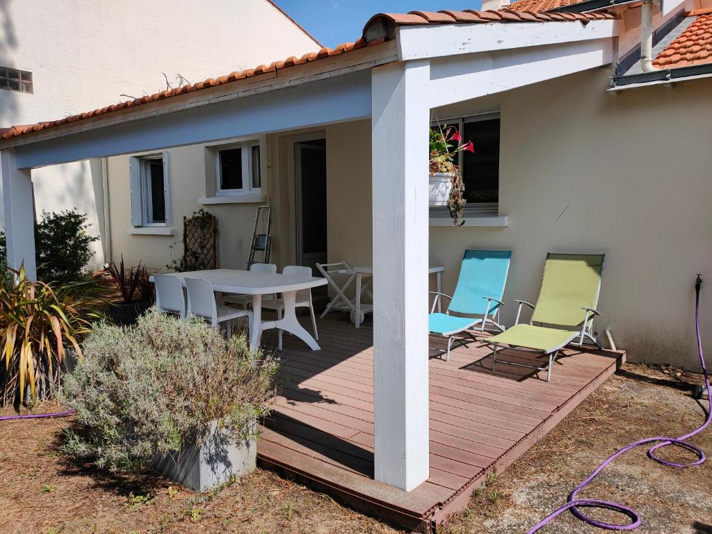a wooden deck with a table and chairs on a house at Villa 100m plage in La Faute-sur-Mer