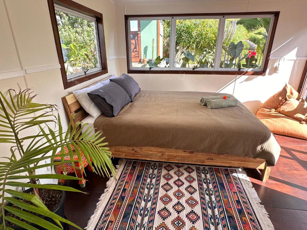 een slaapkamer met een bed en een tapijt bij Pandora Cottage Beachfront in Raglan