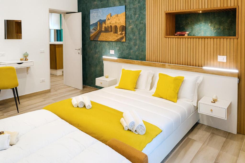 een slaapkamer met een groot bed met gele en witte kussens bij Residence Arechi in Salerno