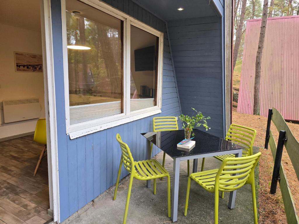 un tavolo e sedie sul portico di una casa di Glücklich am Strand - Ruhe im Kiefernwald mit Terrasse & Hund willkommen a Trassenheide