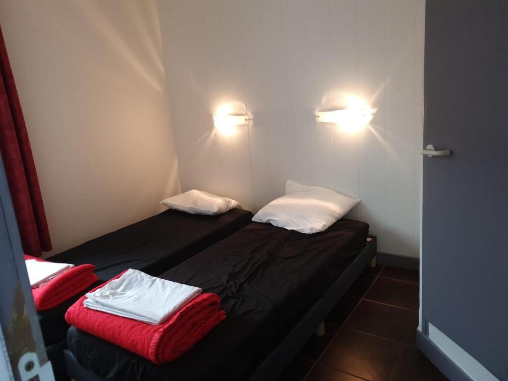 a small room with two beds and two lights at hotel barbery in La Celle-sous-Gouzon