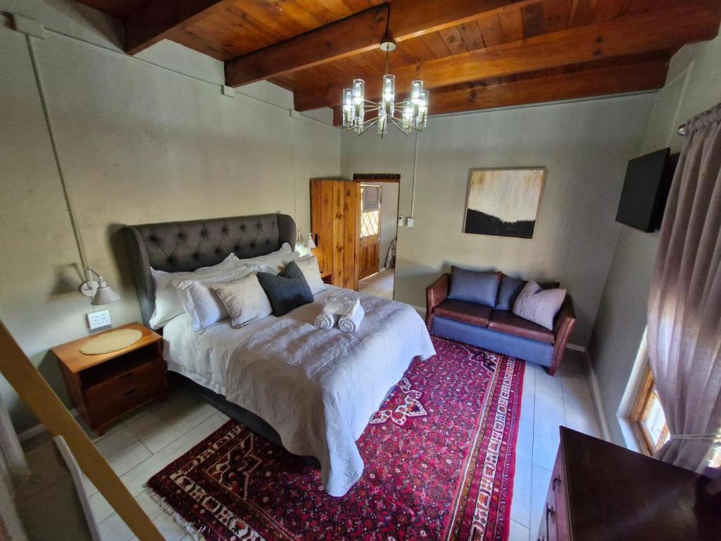 una camera da letto con un letto grande e un divano di Coniston Villa a Colesberg