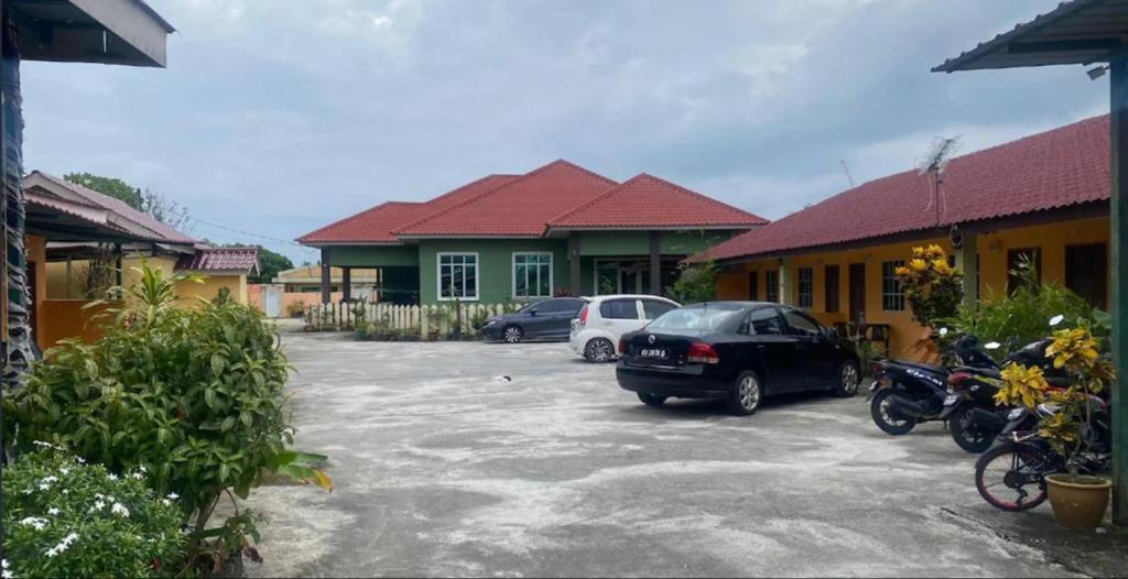 a parking lot with cars parked in front of a building at Collection o Langkawi near pantai cenang formerly tokman inn in Pantai Cenang