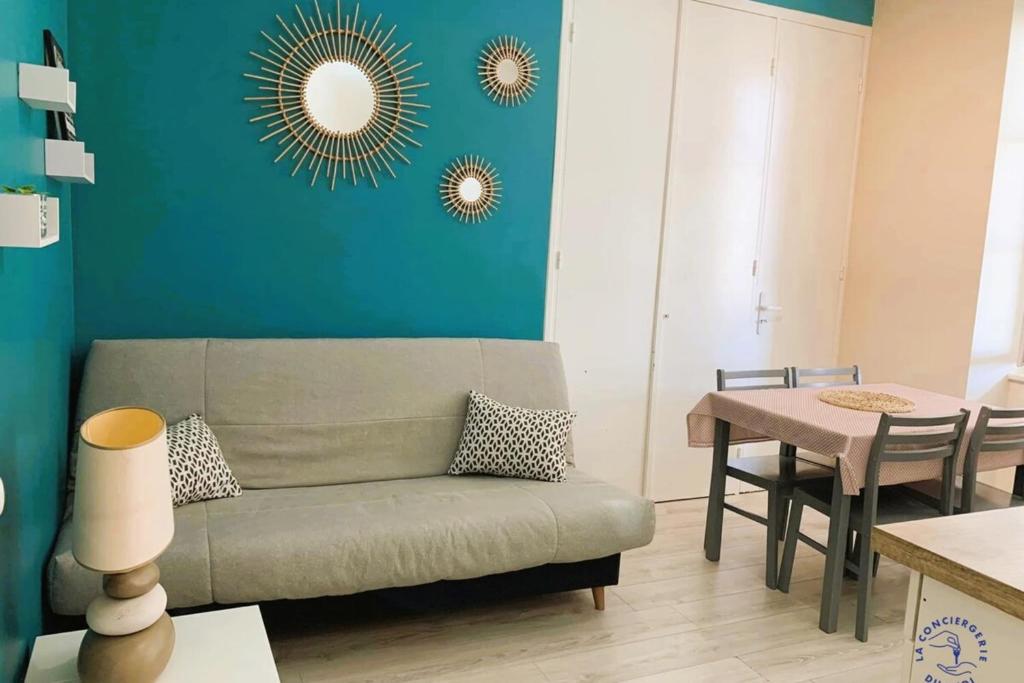 a living room with a couch and a table at Gîte Studio Les Cigales piscine & WIFI in Narbonne