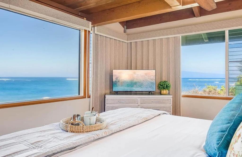 a bedroom with a bed with a view of the ocean at Coastal Paradise Condo with Panoramic Ocean Views in Kahana