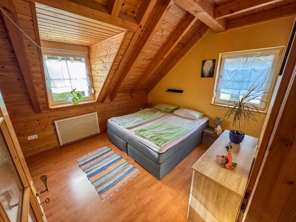 an attic room with a bed and a table at Ferienwohnung zum Kirchturmblick in Dettelbach