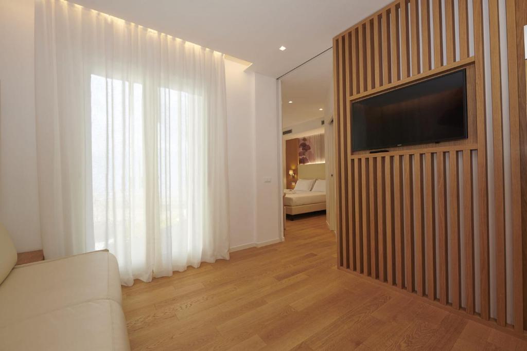 利多迪耶索罗Hotel Cavalieri Palace & Suites的客厅里墙上有一台电视