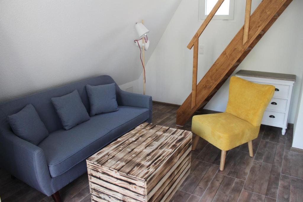 un soggiorno con divano blu e sedia gialla di Finn-Ida a Zinnowitz