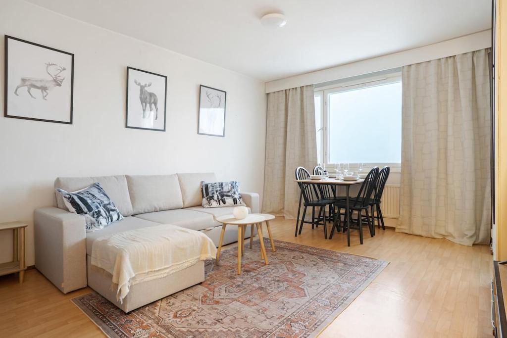 a living room with a couch and a table at Cozy Studio, Free Parking By Lapland Host in Rovaniemi