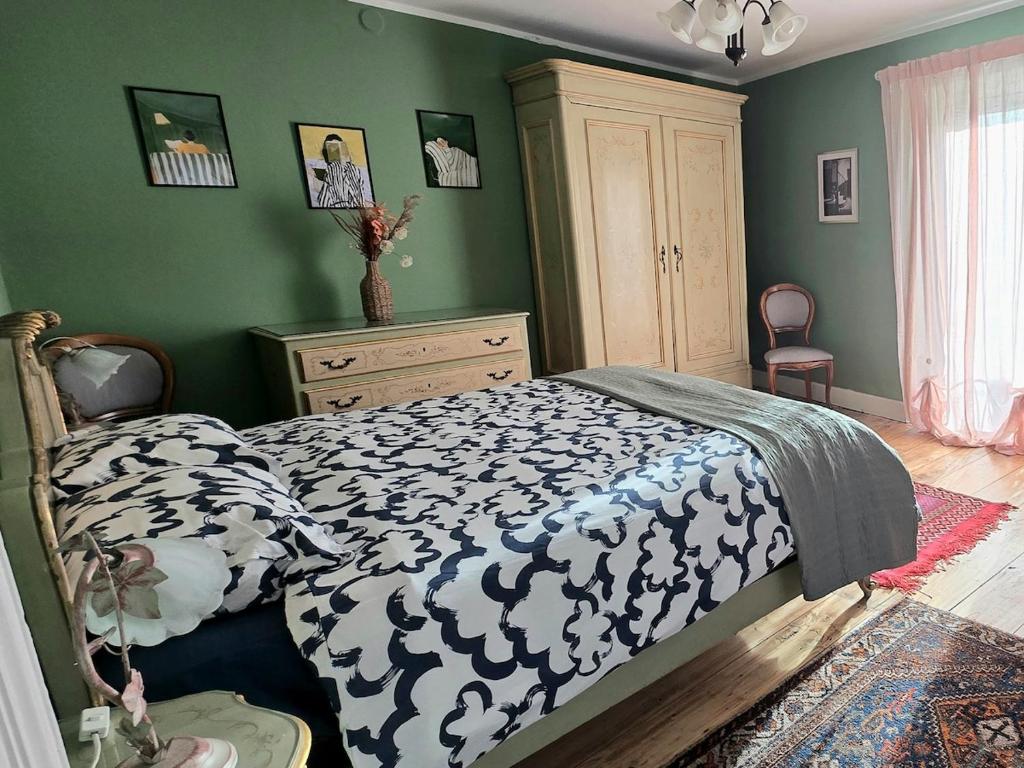 a bedroom with a bed with a black and white comforter at La Quiete del Mattino in Torre Pellice