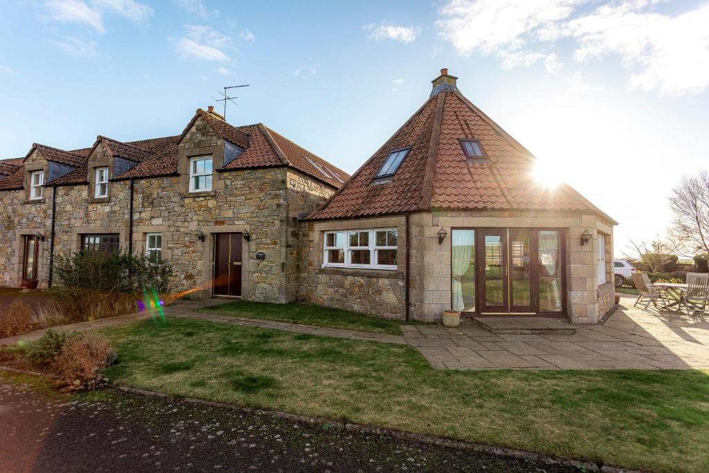 a large stone house with a pitched roof at Swilken Lodge - Blacklaws Steading in Anstruther