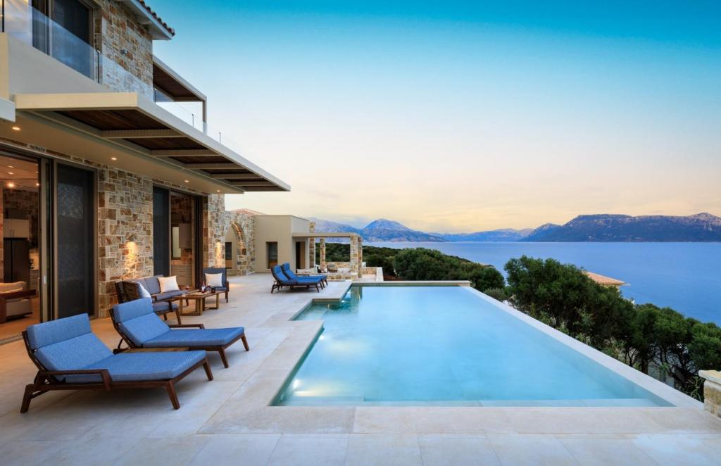 een huis met een zwembad met uitzicht op het water bij Villa Noesis in Katomérion