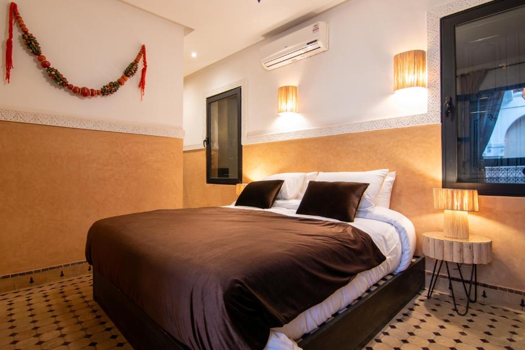 1 dormitorio con cama, ventana y luces en Riad Bloom, en Marrakech