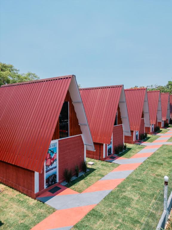 a row of red barns with red roofs at Chalés Portal das Chácaras in Brejo Sêco