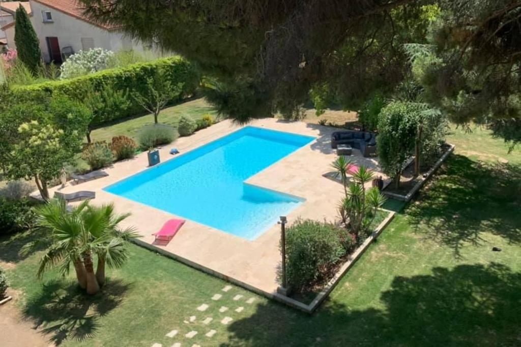 eine Draufsicht auf einen Swimmingpool in einem Hof in der Unterkunft Gîte Studio Les Oliviers in Narbonne