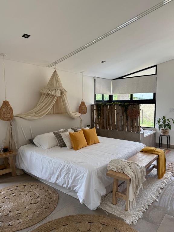 een slaapkamer met een groot wit bed met gele kussens bij Alquimia House in Corrientes