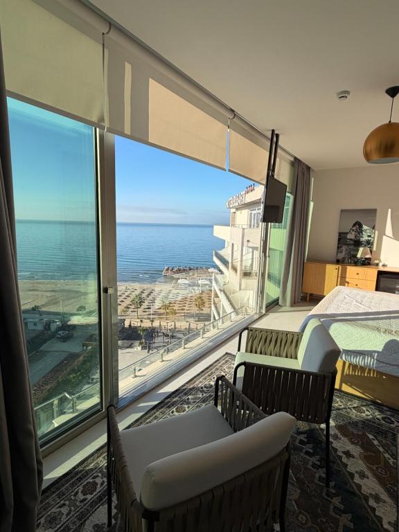 a bedroom with a large window with a view of the ocean at Sky rooftop luxury suites in Durrës