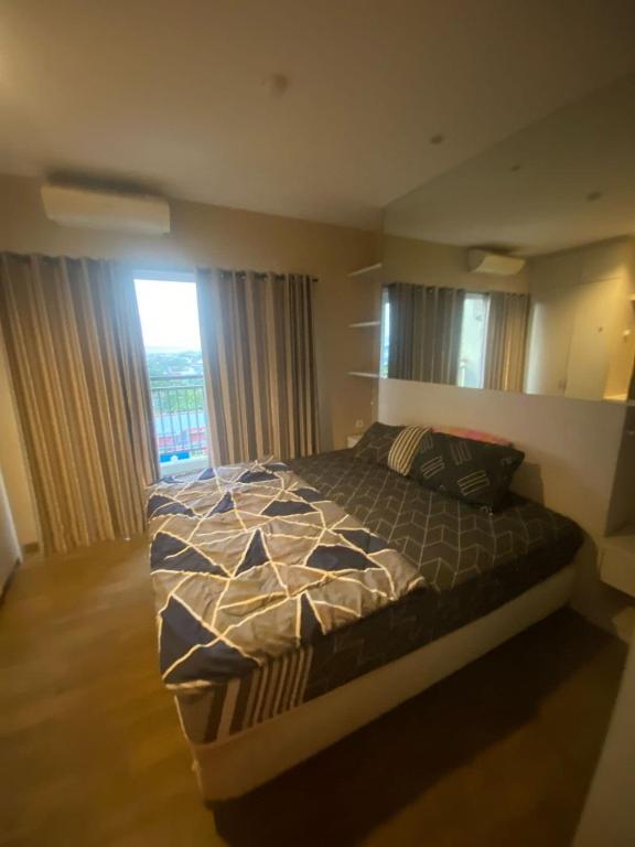 a bedroom with a bed and a window at Studentpark apartment by RD in Yogyakarta