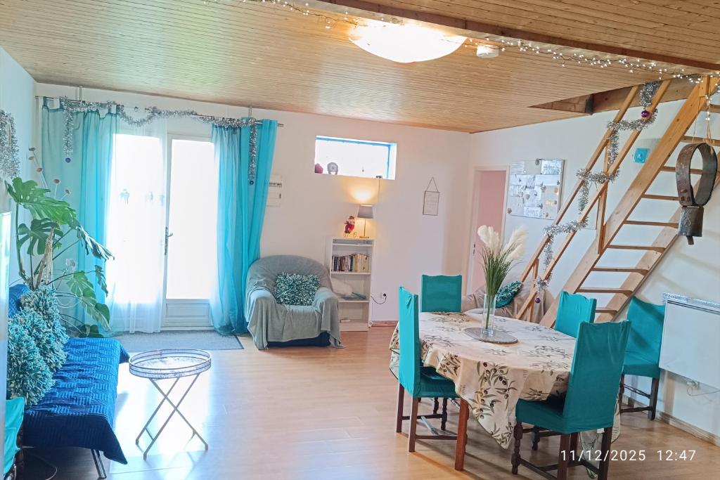 a living room with a table and blue chairs at Maison Datcha Gîte avec jardin et piscine privée in Lavaur