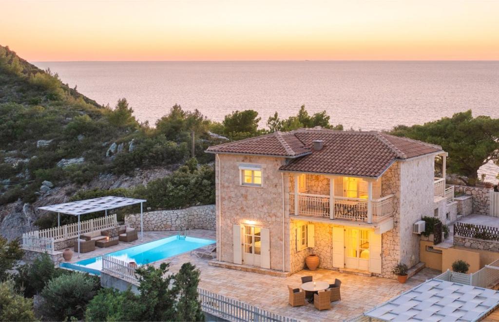 een villa met een zwembad en de oceaan bij Villa Valia in Ayios Nikitas