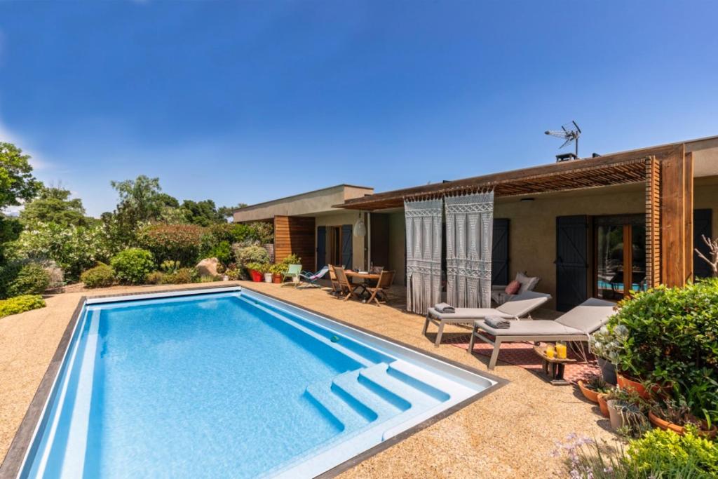 een zwembad in de achtertuin van een huis bij Villa Baccarat in Porto-Vecchio