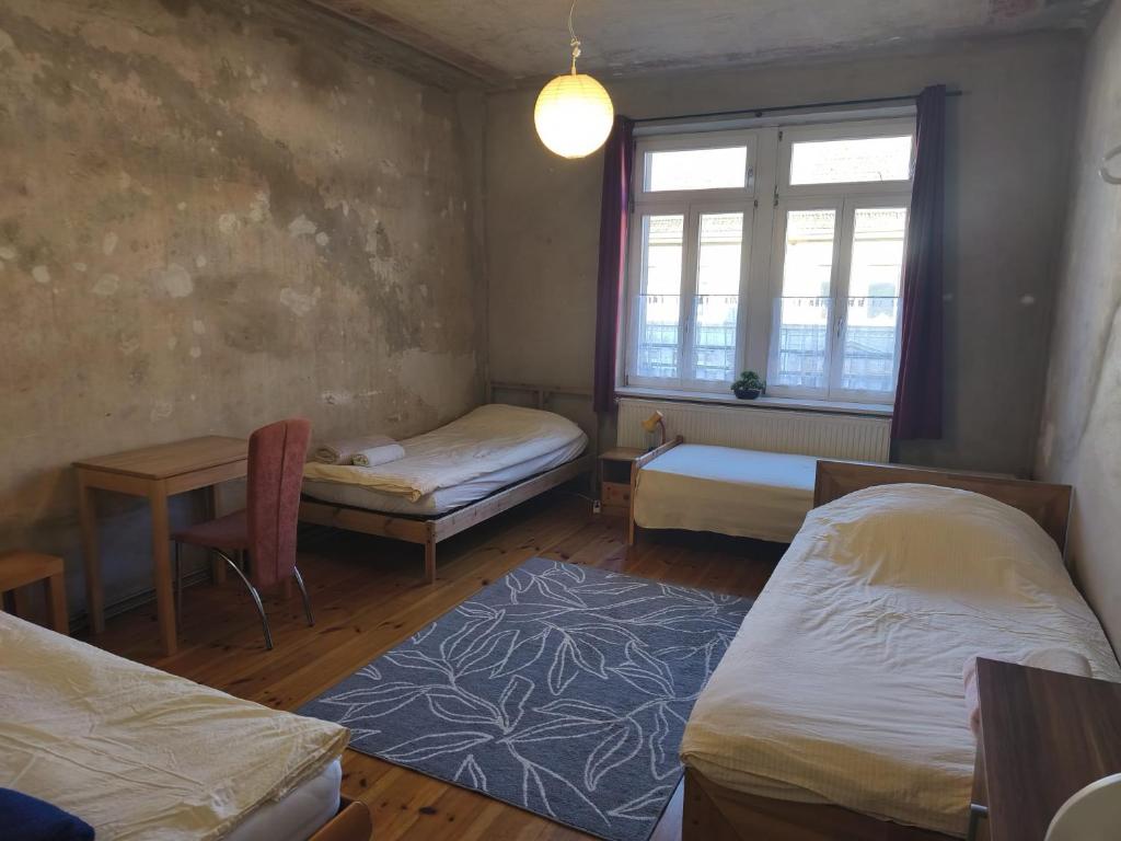 a room with two beds and a window at Grosses Privatzimmer mit Altbau-Charme in Leipzig