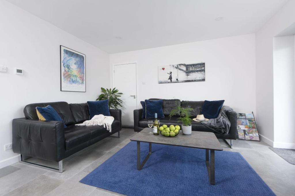 een woonkamer met een bank en een tafel bij 10 The Valley - Free Parking & WiFi, Close To Beaches in Porthcurno