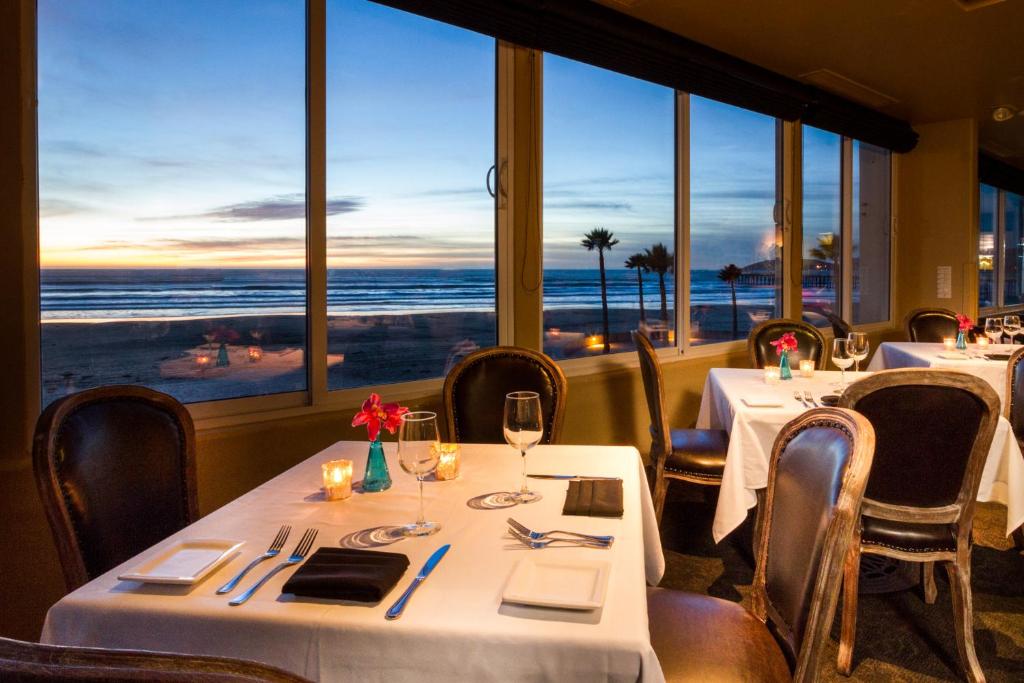 a restaurant with two tables and a view of the ocean at SeaVenture Beach Hotel in Pismo Beach