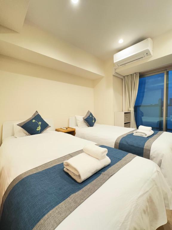 a hotel room with two beds and a window at 中央公馆 Central Mansions 地下鉄谷町六丁目徒步1分心斎橋駅天王寺駅まで電車1本 in Osaka