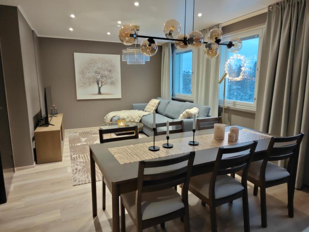 a dining room and living room with a table and chairs at ArticLoft Kemi in Kemi