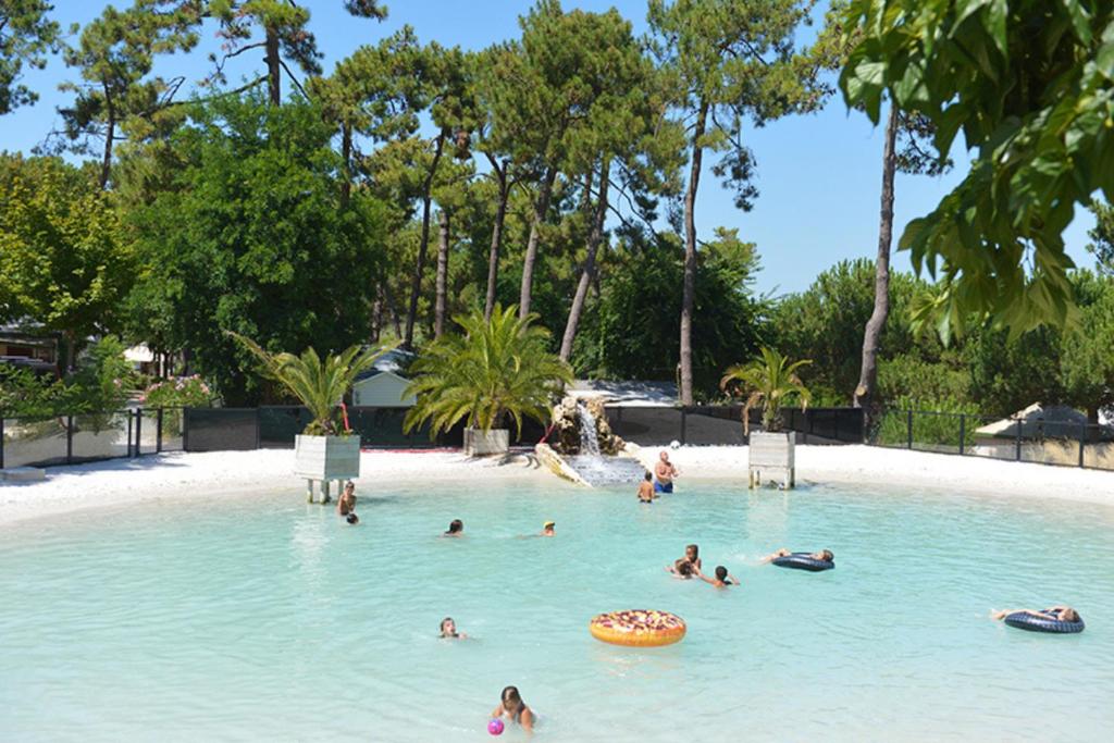 Grand-Village-PlageCamping Les Pins d'Oléron的一群人在游泳池的水中