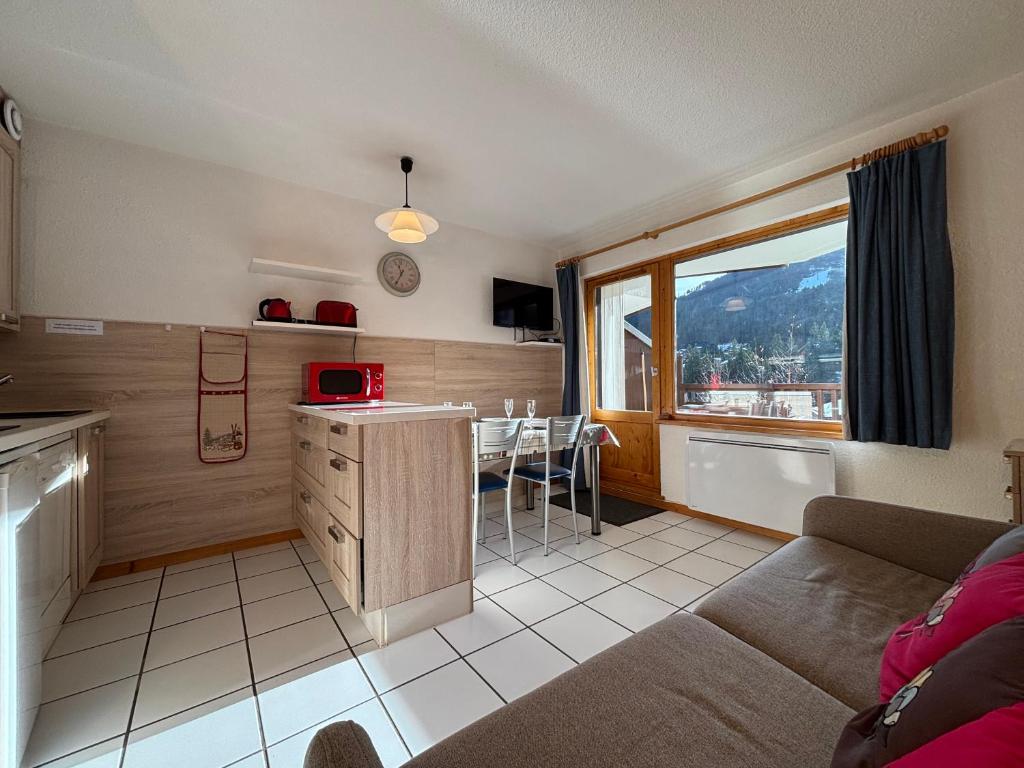 une cuisine et un salon avec un canapé et une table dans l'établissement Résidence Atrey 103 Clés Blanches Courchevel, à Courchevel