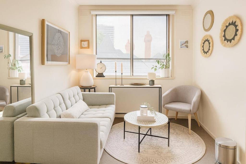 uma sala de estar com um sofá e uma mesa em St Kilda Breeze Cosy Oasis em Melbourne
