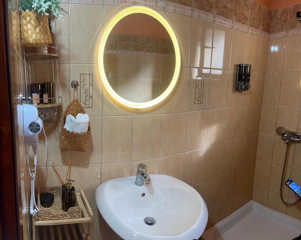 a bathroom with a sink and a mirror and a tub at 4 Seasons Apartment in Leskovik