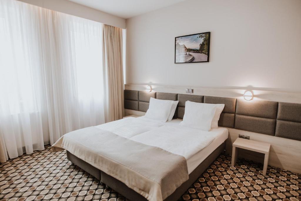 a hotel room with a bed and a window at Piwnica Rycerska Kęty in Kęty