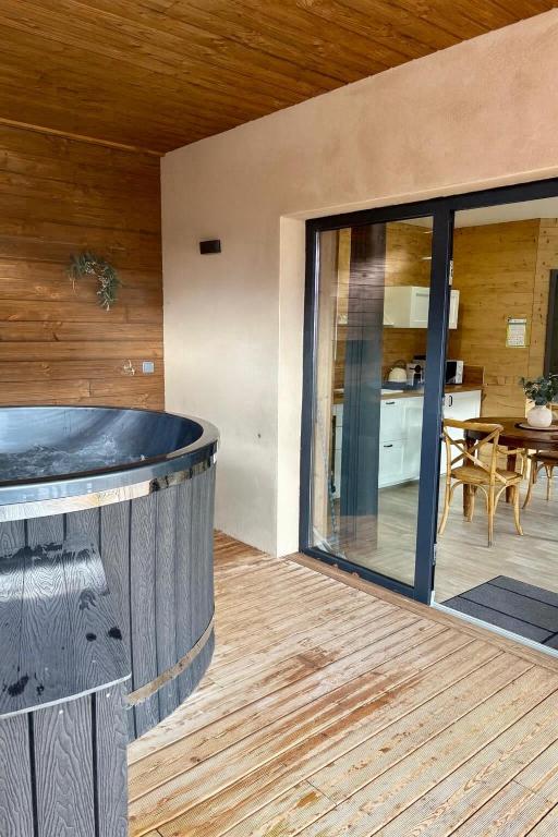 an indoor hot tub in a house with a patio at Chalet Lilas, spa privatif, 2p in Rochesson