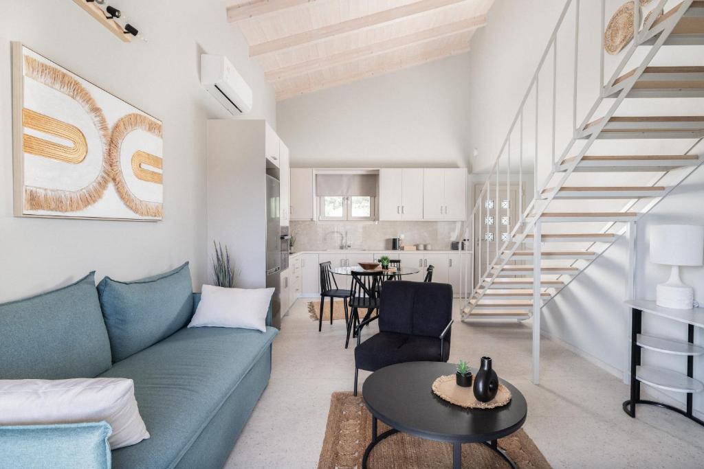 a living room with a blue couch and a staircase at Loft Nikando in Tsilivi