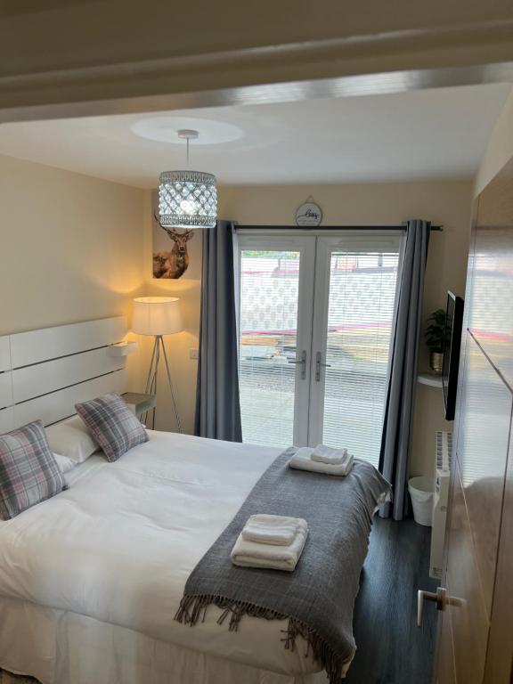 a bedroom with a bed with two towels on it at Canal View Cottage in Winchburgh