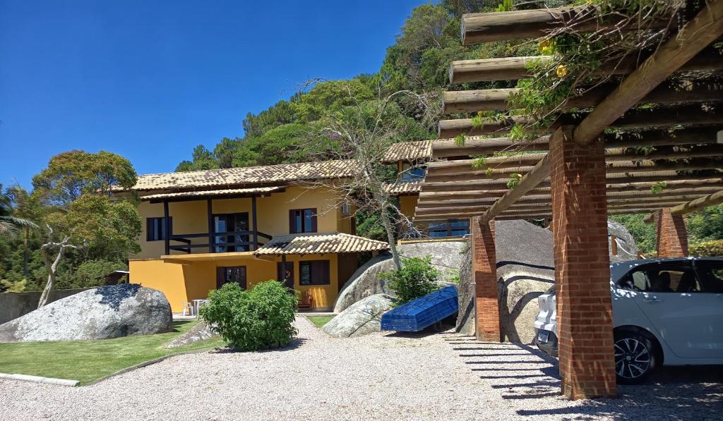a house with a car parked in front of it at Lorena'Haus in Bombinhas