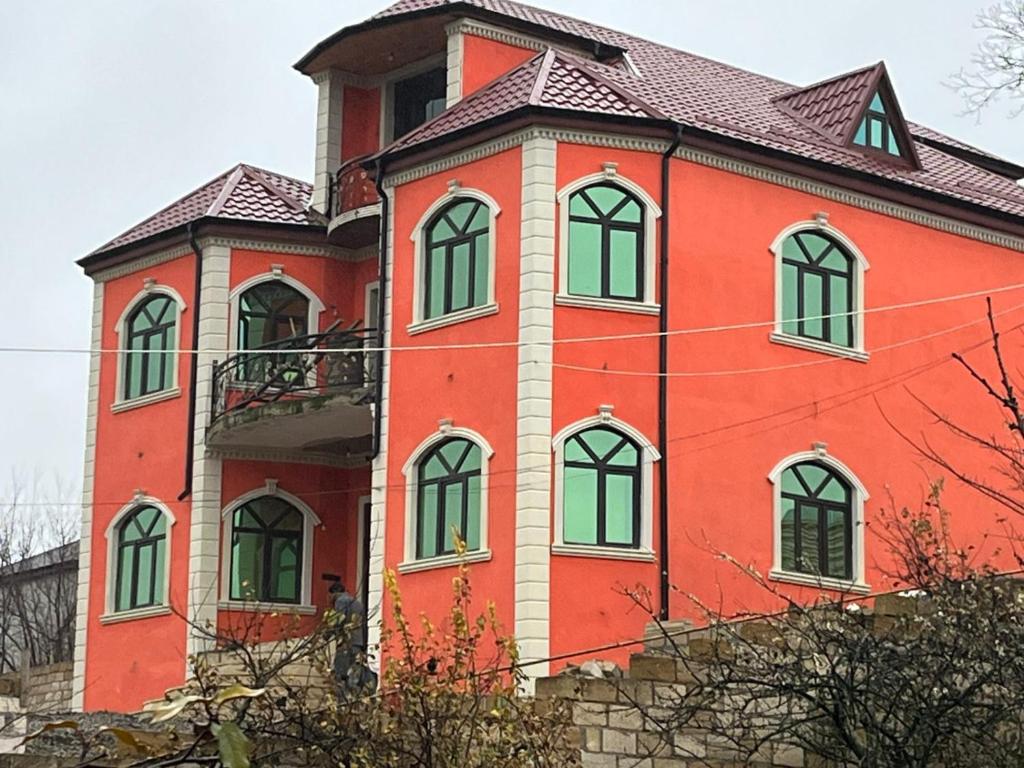 a large red building with green windows on it at Quba Şah Villa in Amsar