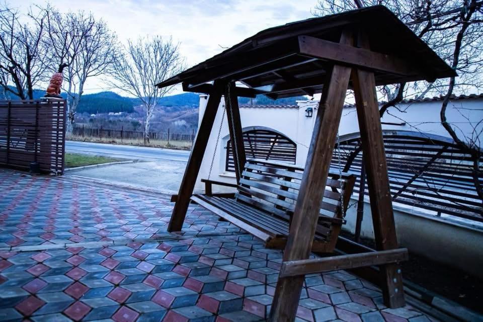 a park bench with a roof on top of it at FLH - Trofeul Cerbului in Negrileşti