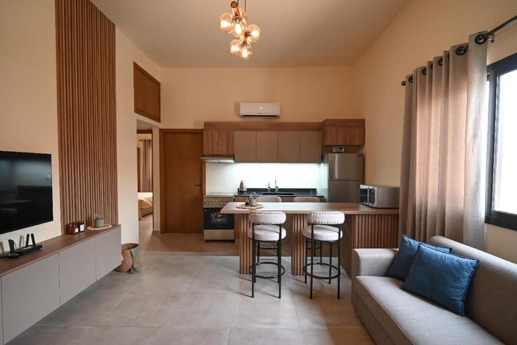 a kitchen and living room with a table and a couch at Sands Guesthouse Apartment 03 In Batroun in Batroûn