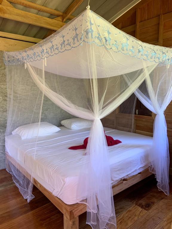 a bed with a canopy in a room at Koh Mook Banana Garden in Ko Libong