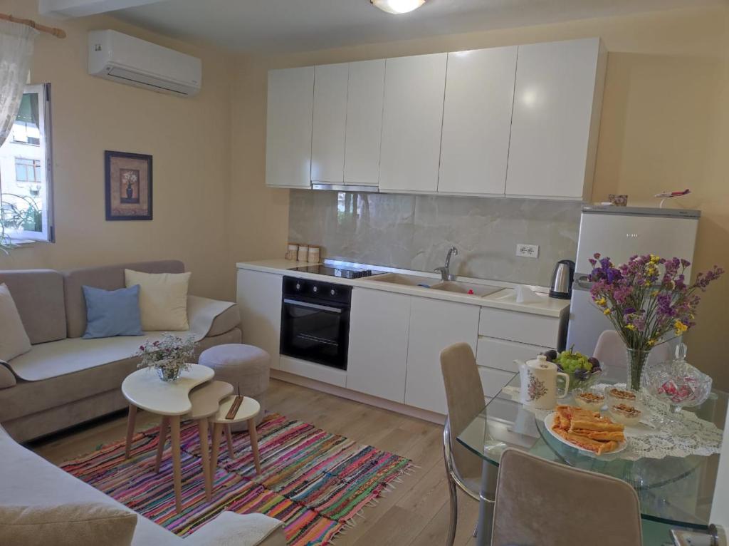 a kitchen and a living room with a table at Quiet, Cozy, Luminous Apartment in Tirana