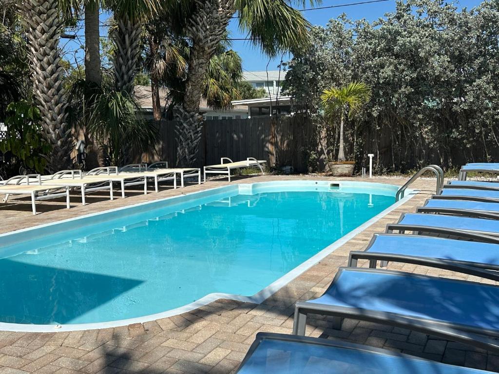 a swimming pool with lounge chairs next to it at 2bd 2ba Beachside E 3Min to Beach Pool! in Clearwater Beach